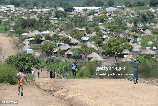 Inhabitants of the Bidi Bidi refugee settlement walking along a road in Uganda, 28 June 2017. Uganda is praised throughout the world: the East...