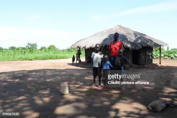 Ugandan Asina Adiru standing with her three children in front of her hut near the Bidi Bidi refugee settlement in northwestern Uganda, 28 June 2017....