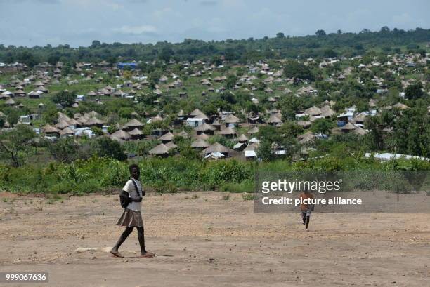 Children walking along a road in the Bidi Bidi refugee settlement in northwestern Uganda, 28 June 2017. Uganda is praised throughout the world: the...