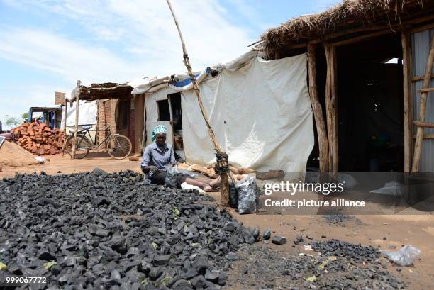 Ugandan Dawa Alli packing coal in plastic bags for sale in the Bidi Bidi refugee settlement in Uganda, 28 June 2017. Uganda is praised throughout the...