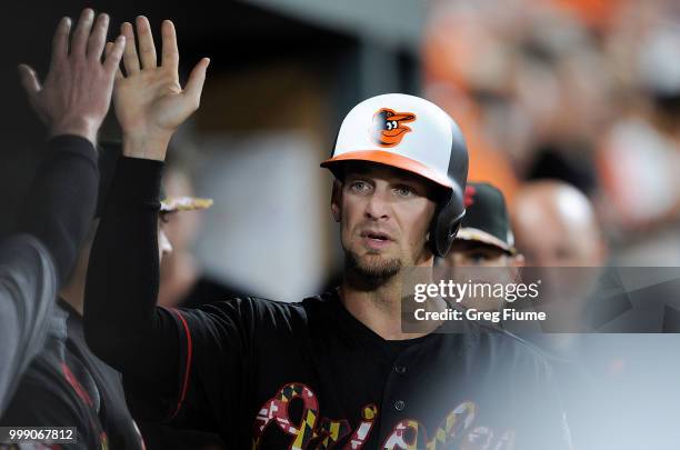 Caleb Joseph of the Baltimore Orioles celebrates with teammates after scoring in the sixth inning against the Texas Rangers at Oriole Park at Camden...