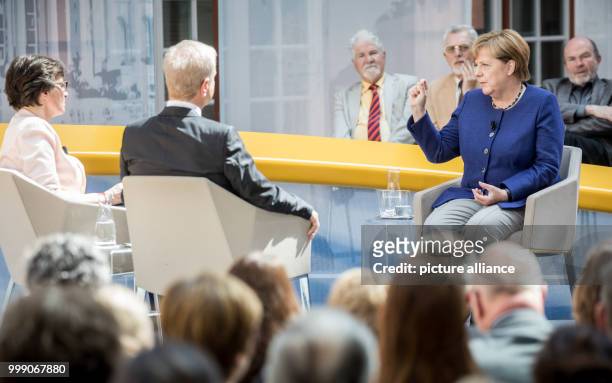 German Chancellor Angela Merkel speaking with journalists Michael Hirz and Birgit Wentzien during the recording of the TV program "Forum Politik" of...
