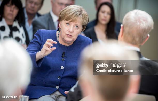 German Chancellor Angela Merkel speaking with journalist Michael Hirz during the recording of the TV program "Forum Politik" of the Phonix...
