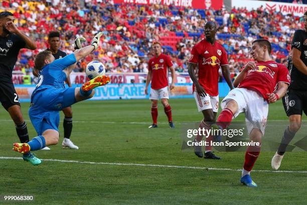 Sporting Kansas City goalkeeper Tim Melia makes a diving save off the flick from New York Red Bulls midfielder Alex Muyl during the first half of the...