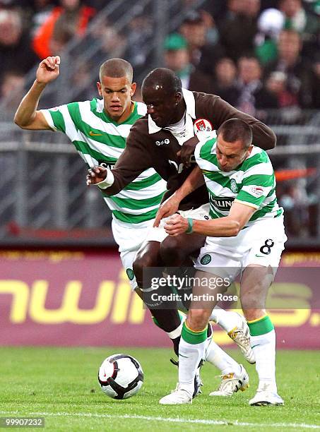 Morike Sako of St. Pauli is challenged by Joshua Thompson and Scott Brown of Celtic during the friendly match between FC St. Pauli and Celtic at the...