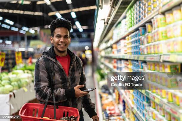 customer buying with mobile app on supermarket - man choosing stock pictures, royalty-free photos & images