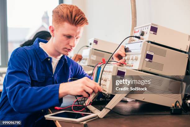 junger mann an einem engineering-projekt arbeiten - solstock stock-fotos und bilder