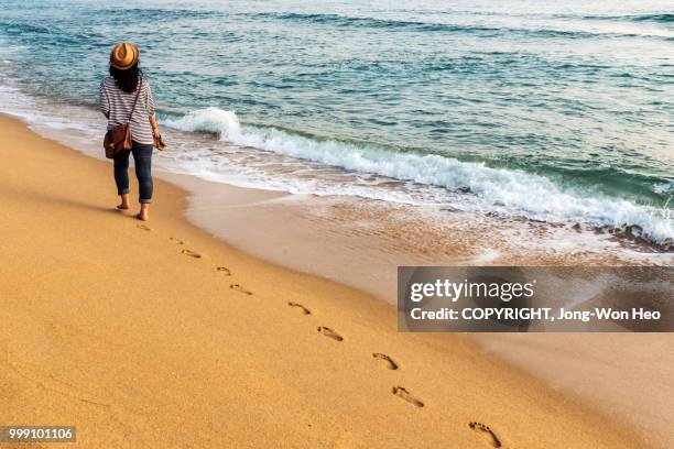 a girl walking along the edge of the sea - jong won heo stock pictures, royalty-free photos & images