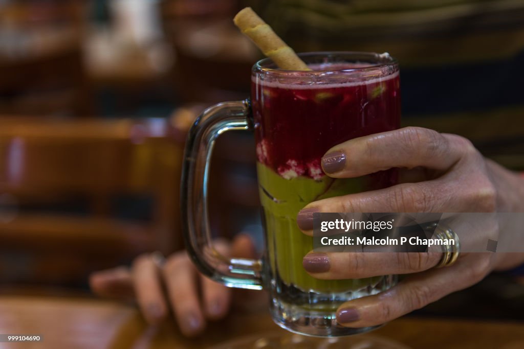 Woman holding glass of Avocado and Strawberry juice, Beirut, Lebanon