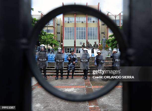 Honduran national police agents stand guard at the Supreme Court's headquarters as teachers, students and members of the National Front of Popular...