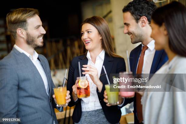 business team taking a break and drinking healthy smoothies - 4 cocktails stock pictures, royalty-free photos & images