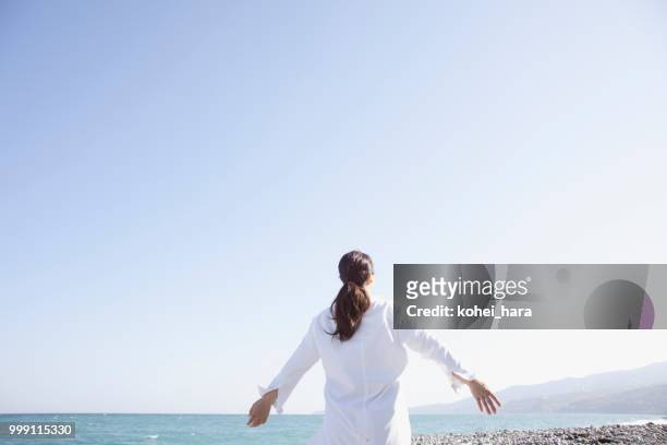 donna rilassata al mare - kohei hara foto e immagini stock