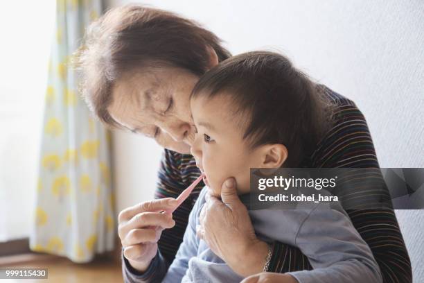 nonna che si lava i denti di suo nipote - kohei hara foto e immagini stock