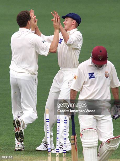 Greg Mail and Stuart Clark of New South Wales celebrate a wicket during the first day of play in the Pura Milk Cup between the Queensland Bulls and...