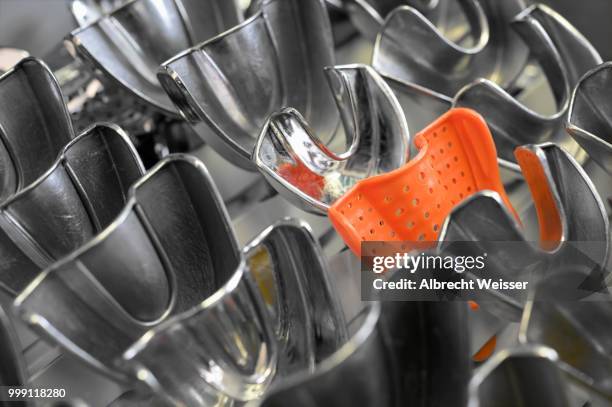 plastic form amidst metal forms for dental imprints, germany - technic stock pictures, royalty-free photos & images