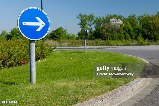 traffic sign on roundabout indicating direction of travel, sign pointing to the right, duesseldorf, rhineland, north rhine-westphalia, germany - road signal ストックフォトと画像