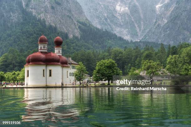 st. bartholomae church with the east wall of watzmann mountain on koenigssee lake in the berchtesgaden alps, upper bavaria, bavaria, germany - berchtesgaden alps stock pictures, royalty-free photos & images