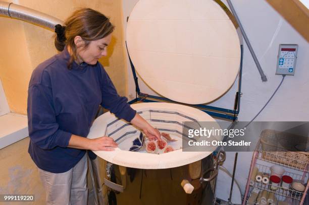 ceramic artist removing fired ceramic items from a kiln, geisenhausen, bavaria, germany - bricolage stock-fotos und bilder