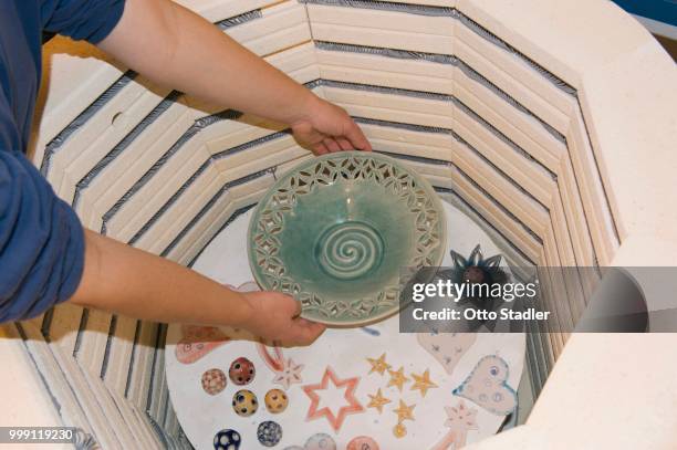 ceramic artist removing fired ceramic items from a kiln, geisenhausen, bavaria, germany - bricolaje stock pictures, royalty-free photos & images