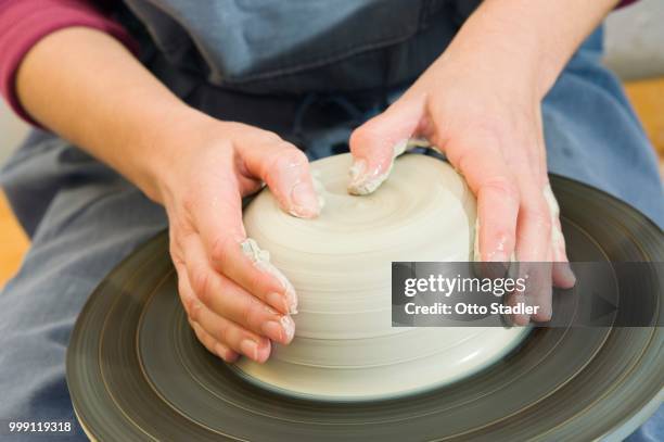 ceramic artist working in her workshop with a potter's wheel, turning and centering, geisenhausen, bavaria, germany - bricolaje stock pictures, royalty-free photos & images