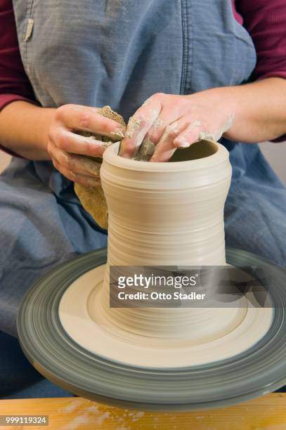 ceramic artist working in her workshop with a potter's wheel, pulling a cylinder, geisenhausen, bavaria, germany - bricolage stock-fotos und bilder