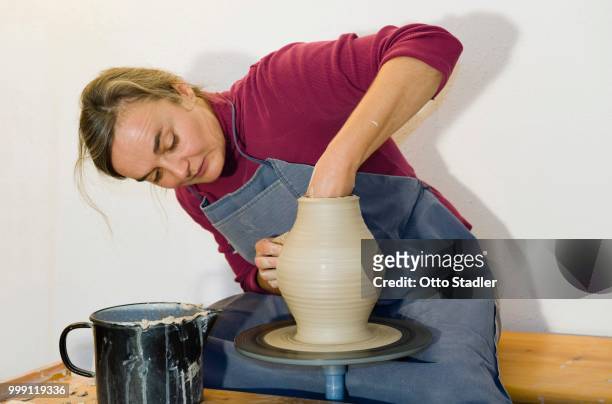 ceramic artist working in her workshop with a potter's wheel, turning a vase, geisenhausen, bavaria, germany - bricolaje stock pictures, royalty-free photos & images
