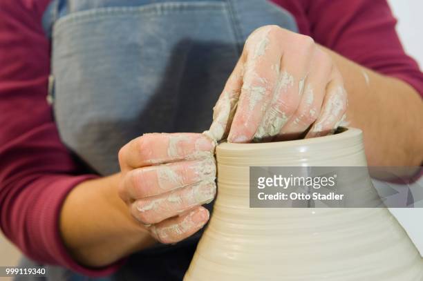 ceramic artist working in her workshop with a potter's wheel, turning a vase, geisenhausen, bavaria, germany - bricolage stock-fotos und bilder