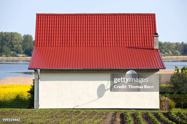 small house without windows, with a satellite dish on lake spyker see, ruegen, rugia, mecklenburg-western pomerania, germany - technic stock pictures, royalty-free photos & images