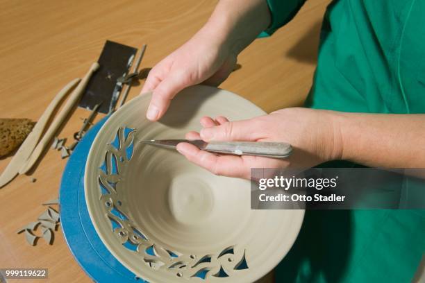 ceramic artist working in her workshop, cutting a pattern into a bowl, geisenhausen, bavaria, germany - bricolaje stock pictures, royalty-free photos & images