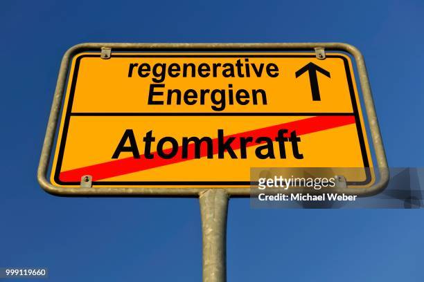 symbolic image in the form of a town sign, in german, exit from atomic power, entrance into regenerative energy sources - freund oder freundlichkeit stock-fotos und bilder