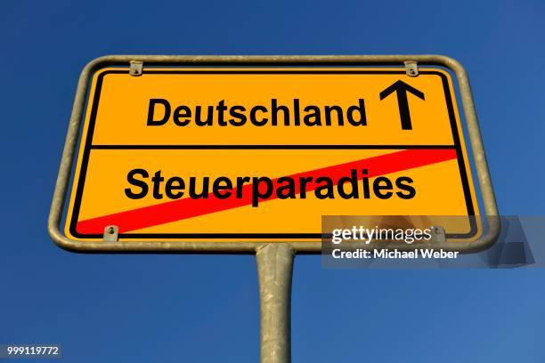 city limit sign, symbolic image for the way from a steuerparadies to deutschland, german for going from a tax haven to germany - deutschland stockfoto's en -beelden