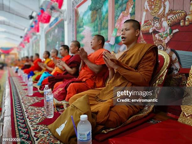 row of thai buddhist monks chanting during a buddhist ceremony. - theravada stock pictures, royalty-free photos & images
