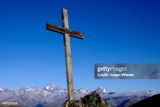 summit cross on nufenenpass at 2478 m, behind the bernese alps with mt. finsteraarhorn, 4274m and mt. lauteraarhorn, 4043m, canton valais, switzerlandd - valais canton photos et images de collection