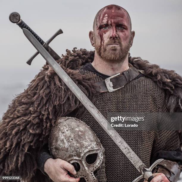 weapon wielding bloody medieval warrior alone on a cold seashore - armory stock pictures, royalty-free photos & images