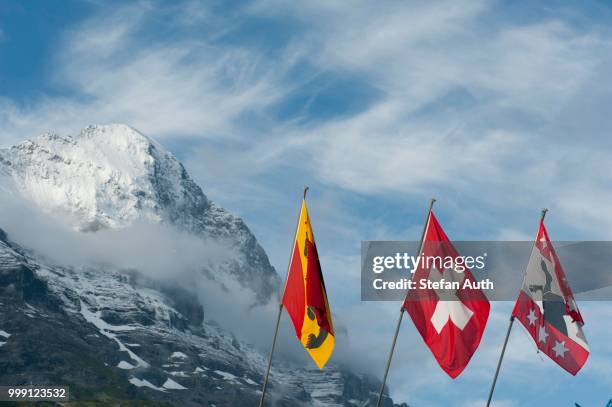 flags in front of the snow-covered eiger mountain, 3970 m, north wall, the alps, grindelwald, bernese oberland, canton of bern, switzerland - north canton stock pictures, royalty-free photos & images