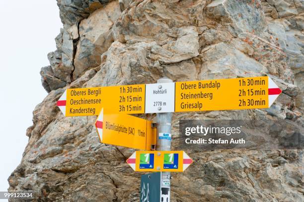 yellow sign of the swiss alpine club, sac, in front of rocks, hohtuerli pass 2778 m, between griesalp and kandersteg, the alps, bernese oberland, canton of bern, switzerland - kandersteg stock pictures, royalty-free photos & images