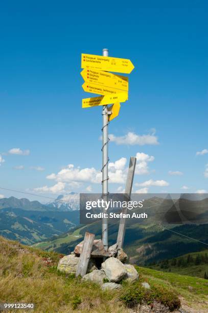 yellow sign of the austrian alpine club, oeav, pinzgauer walk, with leogang stone mountains in the background, kitzbuehel alps, saalbach-hinterglemm, salzburg, austria - north tirol stock pictures, royalty-free photos & images