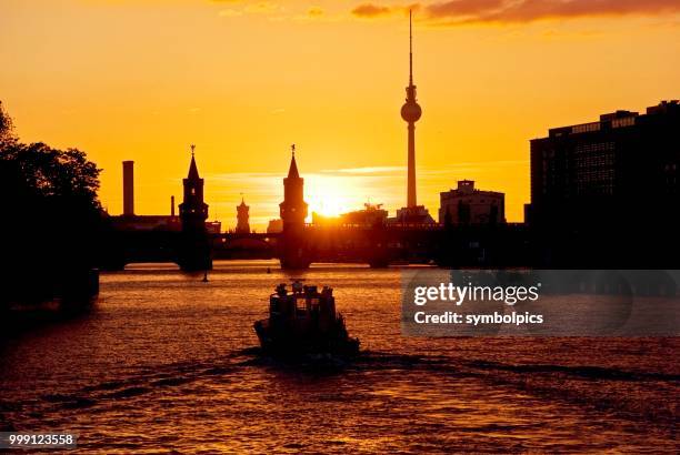 oberbaumbruecke bridge, boat, sunset, berlin, germany - silhouette contre jour fotografías e imágenes de stock