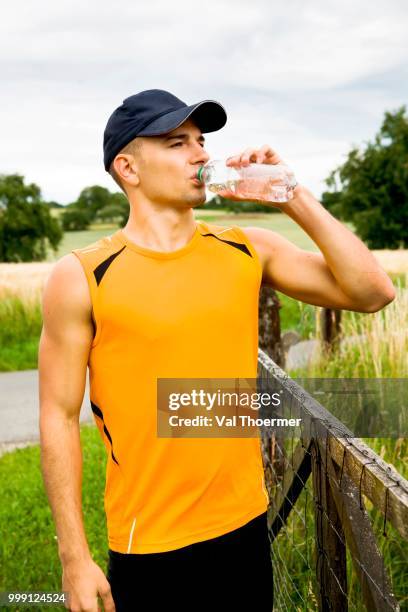 jogger taking a break, drinking, near coburg, bavaria, germany - oberfranken stock-fotos und bilder