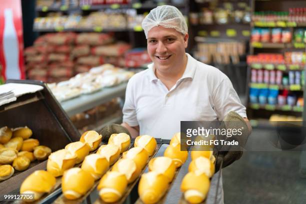 baker showing fresh bread - food staple stock pictures, royalty-free photos & images