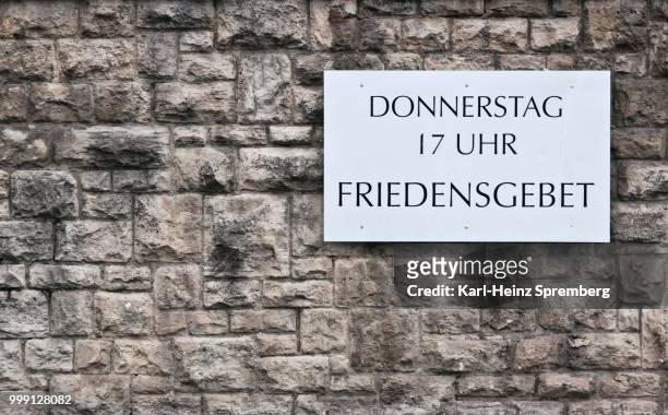 --donnerstag 17 uhr friedensgebet-- german for --thursday, 5pm, prayer for peace--, sign on a church wall, erfurt, thuringia, germany - uhr foto e immagini stock