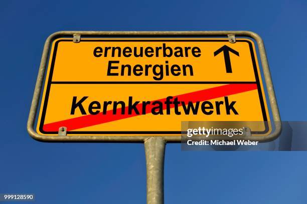 city limits sign with the words erneuerbare energien and kernkraftwerk, german for renewable energy and nuclear power station, symbolic image for the end of nuclear power through the use of renewable energy - freund oder freundlichkeit stock-fotos und bilder