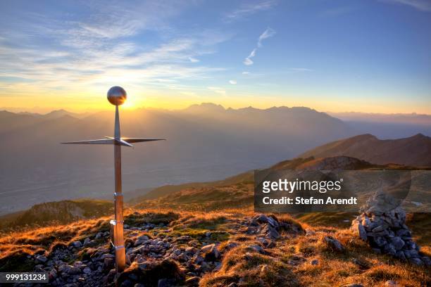 summit cross of mt margelkopf above the rhine valley at dawn in autumn, swiss alps, switzerland - contre jour stock-fotos und bilder