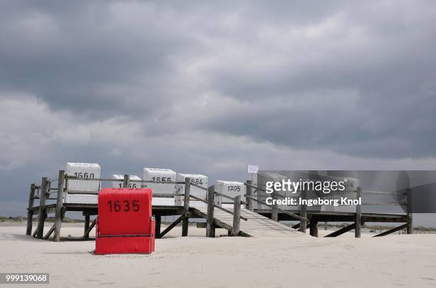 roofed wicker beach chairs on a platform on stilts, beach on the north sea, st. peter-ording, schleswig-holstein, germany - sleeswijk holstein stockfoto's en -beelden