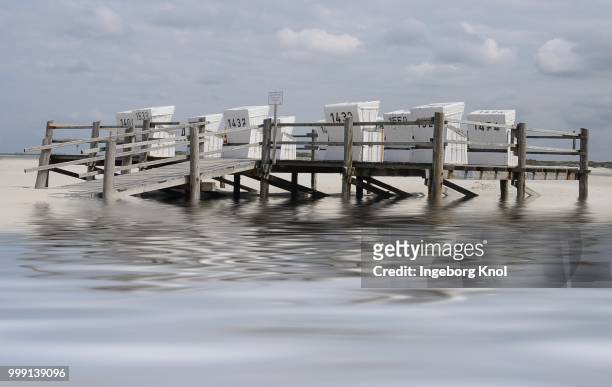 white roofed wicker beach chairs on a platform on stilts, beach on the north sea, st. peter-ording, schleswig-holstein, germany - sleeswijk holstein stockfoto's en -beelden