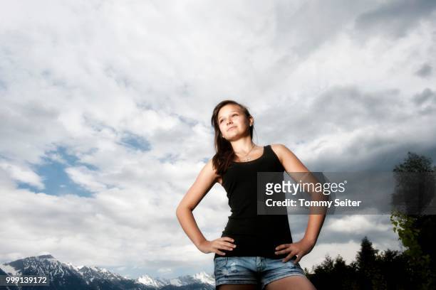 girl, 14 years, looking up thoughtfully, in front of cloudy sky, tyrol, austria - 14 15 years stock-fotos und bilder