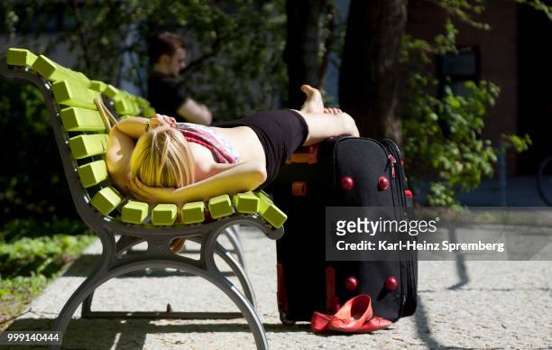 woman lying on a green park bench, relaxing, berlin, germany - green park stock pictures, royalty-free photos & images