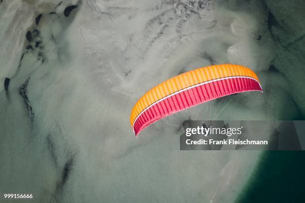 paraglider over the maggia river delta with naturally formed water and rocks terrain, locarno, kanton tessin, switzerland - kanton tessin stock pictures, royalty-free photos & images