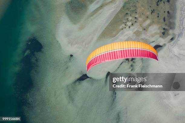 paraglider over the maggia river delta with naturally formed water and rocks terrain, locarno, kanton tessin, switzerland - kanton tessin stock pictures, royalty-free photos & images