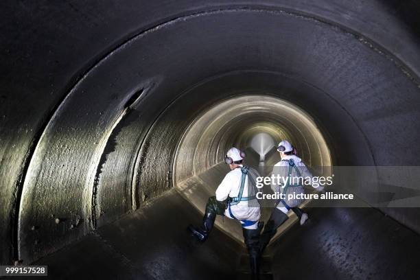 Sewer workers in the subterranean sewage system during an inspection patrol in Schweinfurt, Germany, 17 July 2017. A high-pressure cleaner can be...